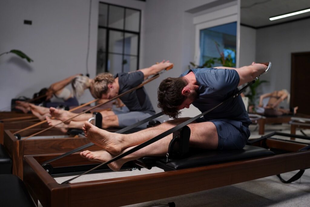 Ludzie ćwiczący pilates na maszynach